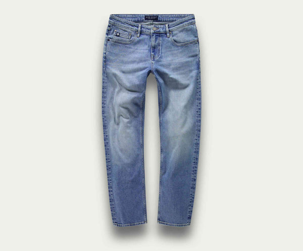 De N01 Straight Stone Bleached jeans van Blue Rivet Jeans worden plat tegen een effen achtergrond getoond. Deze lichtblauwe denim jeans hebben een rechte pasvorm voor een klassieke look, met een subtiel vervaagd effect op de dijen en knieën, samen met standaard zakken en riemlussen.