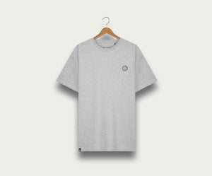 De N01 Tee Grey Melee van Blue Rivet Jeans, ontworpen in een normale pasvorm, hangt aan een houten hanger tegen een lichtgekleurde achtergrond. Het heeft een klein rond logo op de linkerborst.