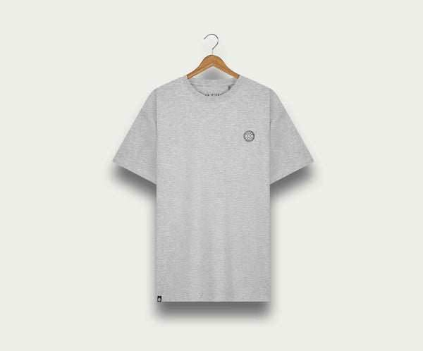De N01 Tee Grey Melee van Blue Rivet Jeans, ontworpen in een normale pasvorm, hangt aan een houten hanger tegen een lichtgekleurde achtergrond. Het heeft een klein rond logo op de linkerborst.