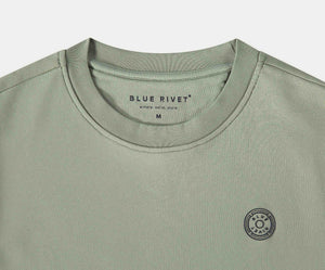 De N01 Sweat Seagrass is een licht olijfgroen t-shirt gemaakt van biologisch katoen, met een ronde hals en het Blue Rivet Jeans merk gedrukt in de kraag. Het toont ook een klein zonachtig rond logo op de linkerborst. Verkrijgbaar in maat Medium.