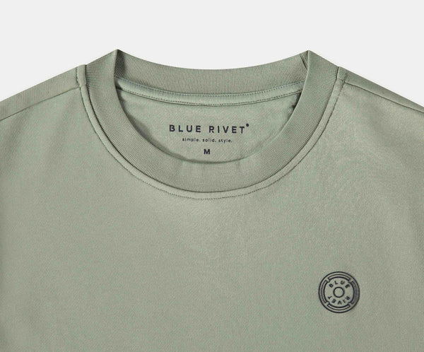 De N01 Sweat Seagrass is een licht olijfgroen t-shirt gemaakt van biologisch katoen, met een ronde hals en het Blue Rivet Jeans merk gedrukt in de kraag. Het toont ook een klein zonachtig rond logo op de linkerborst. Verkrijgbaar in maat Medium.