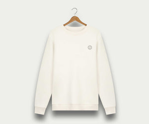 Aan een houten hanger tegen een witte achtergrond hangt The N01 Sweat Off White van Blue Rivet Jeans, een effen witte herentrui met een klein rond logo op de linkerborst en gemaakt van biologisch katoen.