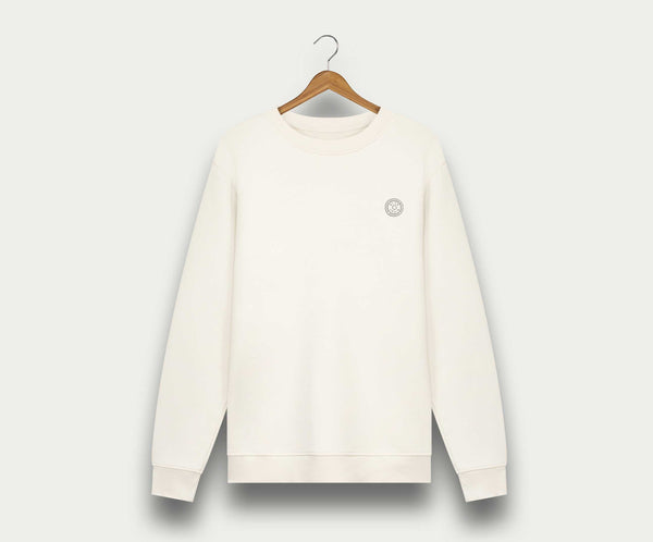 Aan een houten hanger tegen een witte achtergrond hangt The N01 Sweat Off White van Blue Rivet Jeans, een effen witte herentrui met een klein rond logo op de linkerborst en gemaakt van biologisch katoen.