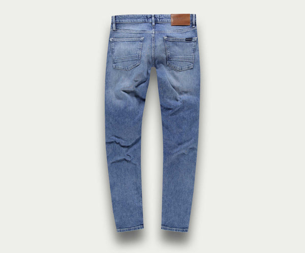 Achteraanzicht van The N01 Slim Stone Bleached jeans van Blue Rivet Jeans op een lichte achtergrond. Deze premium blauwe jeans, of spijkerbroek, heeft twee achterzakken en een bruine leren patch op de tailleband.