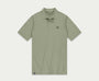 Introductie van de N01 Polo Seagrass van Blue Rivet Jeans: een lichtgroene polo met korte mouwen en een subtiel logo op de linkerborst. Dit shirt is ontworpen met een klassieke kraag en een sluiting met drie knopen, gepresenteerd tegen een effen witte achtergrond.