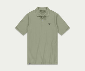 Introductie van de N01 Polo Seagrass van Blue Rivet Jeans: een lichtgroene polo met korte mouwen en een subtiel logo op de linkerborst. Dit shirt is ontworpen met een klassieke kraag en een sluiting met drie knopen, gepresenteerd tegen een effen witte achtergrond.