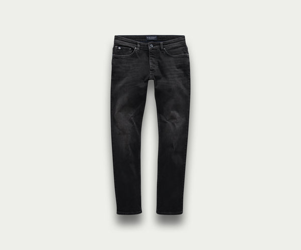 De N01 Slim Black Used jeans van Blue Rivet Jeans worden getoond op een lichtgrijze achtergrond, met een tijdloos five-pocket design en een knoopsluiting bij de tailleband. De denim heeft een licht vervaagde look, wat zorgt voor die ideale gedragen look.