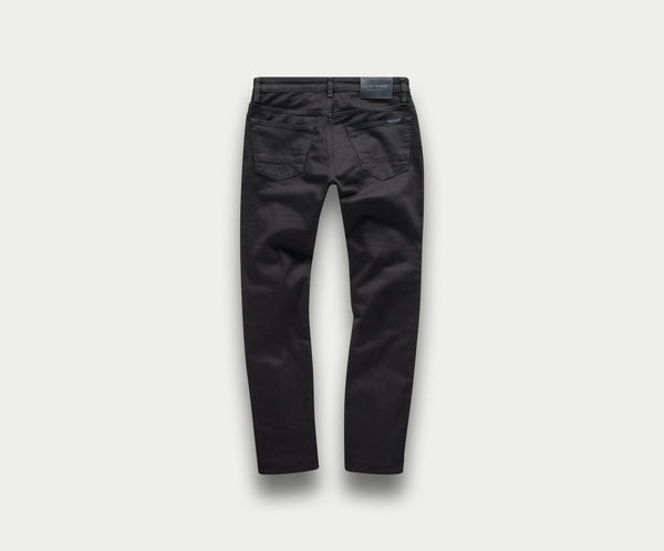 Achteraanzicht van The N01 Slim Black jeans van Blue Rivet Jeans op een lichtgrijze achtergrond. Deze premium zwarte jeans hebben achterzakken en een zichtbaar taillebandlabel, wat de klassieke, slim-fit stijl benadrukt met extra stretch voor verbeterd comfort.
