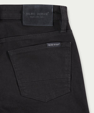 Close-up van de achterzak van de N01 Slim Black jeans van Blue Rivet Jeans, met een structuurstof en nette stiksels, met een BLUE RIVET-label boven en op de tailleband.