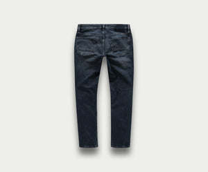 De achterkant toont de N01 Slim Blue Black jeans van Blue Rivet Jeans. Deze premium jeans zijn gemaakt van donker denim met een rechte pijp, gemaakt van stretchstof voor meer comfort en pasvorm. Met zichtbare stiksels en twee achterzakken wordt de spijkerbroek getoond tegen een effen witte achtergrond.