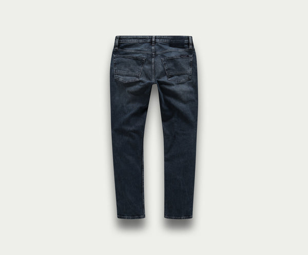 De achterkant toont de N01 Slim Blue Black jeans van Blue Rivet Jeans. Deze premium jeans zijn gemaakt van donker denim met een rechte pijp, gemaakt van stretchstof voor meer comfort en pasvorm. Met zichtbare stiksels en twee achterzakken wordt de spijkerbroek getoond tegen een effen witte achtergrond.