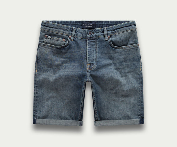 De N01 Short Dark Indigo Vintage van Blue Rivet Jeans is een denim short met een klassiek five-pocket design, platgelegd afgebeeld. De shorts hebben opgerolde boorden en subtiele vervaging voor een perfect ingedragen look.