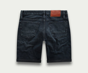 De N01 Short Blue Black van Blue Rivet Jeans is een zwarte denim short met opgerolde pijpen, twee achterzakken en een bruine leren patch op de tailleband tegen een lichte achtergrond.