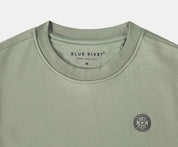 De N01 Sweat Seagrass is een licht olijfgroen t-shirt gemaakt van biologisch katoen, met een ronde hals en het Blue Rivet Jeans merk gedrukt in de kraag. Het toont ook een klein zonachtig rond logo op de linkerborst. Verkrijgbaar in maat Medium.