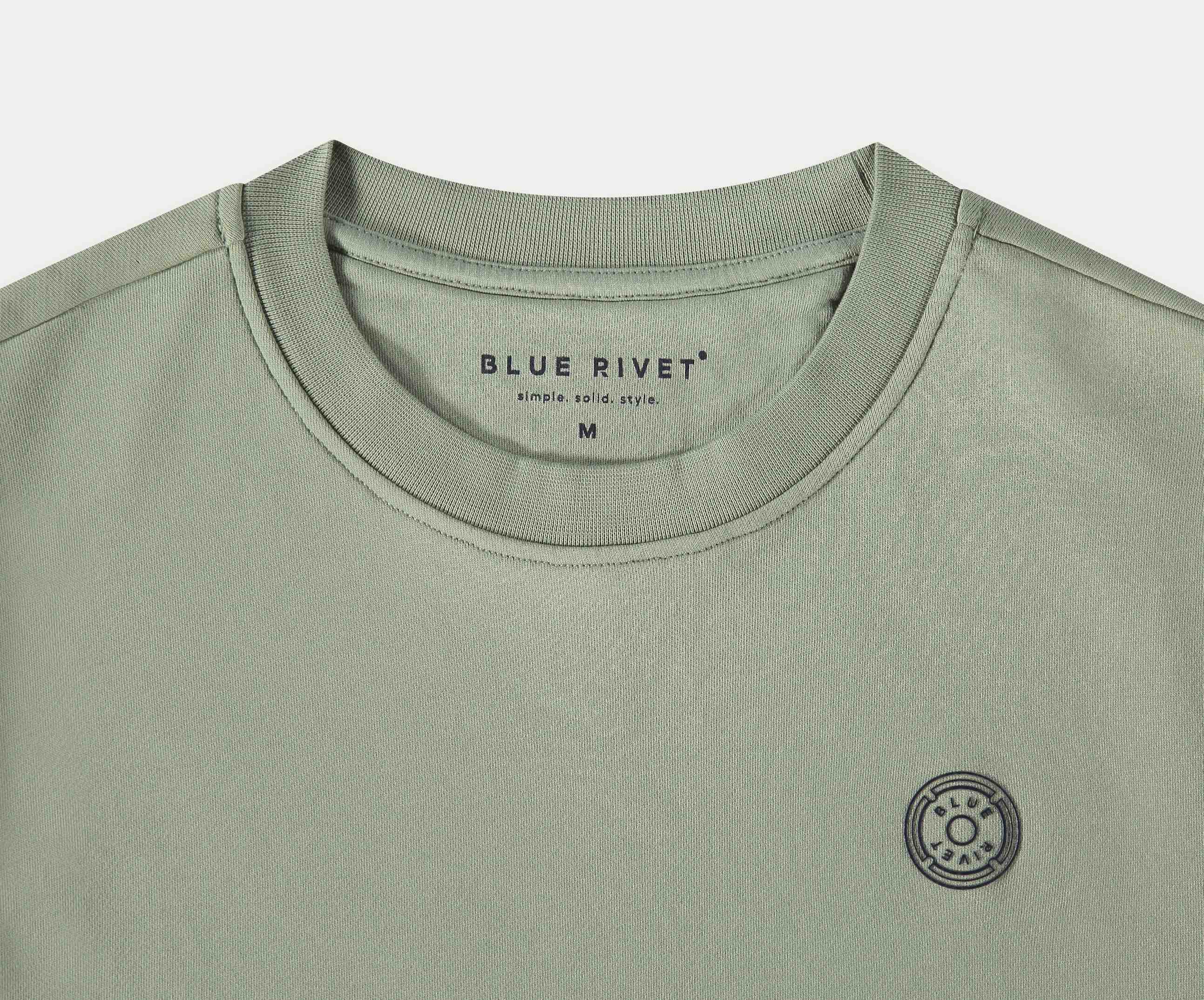De N01 Sweat Seagrass is een licht olijfgroen t-shirt gemaakt van biologisch katoen, met een ronde hals en het Blue Rivet Jeans merk gedrukt in de kraag. Het toont ook een klein zonachtig rond logo op de linkerborst. Verkrijgbaar in maat Medium.