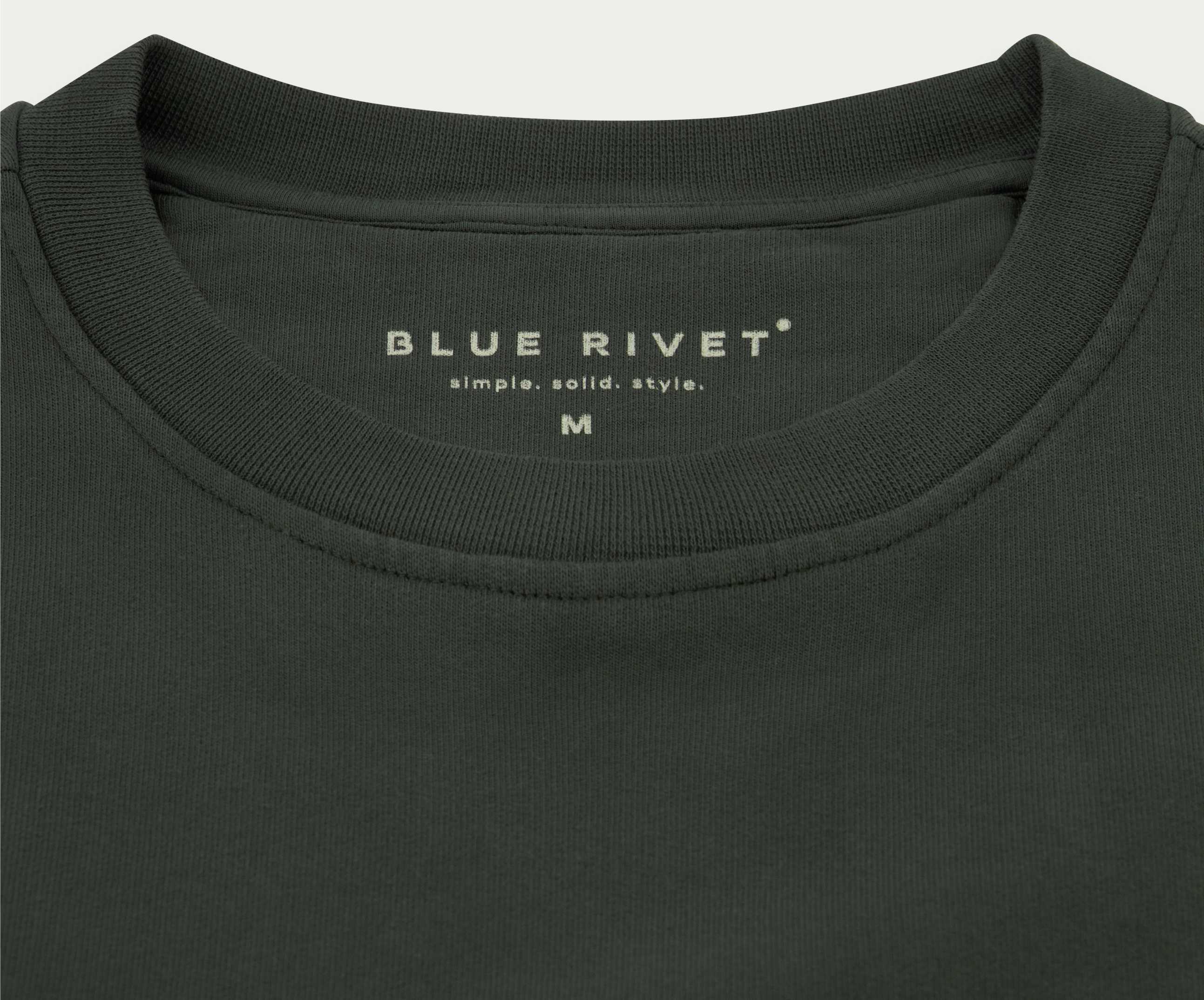 De N01 Sweat Dark Green van Blue Rivet Jeans is een donkergroen T-shirt met ronde hals met "simple. solid. style." en "BLUE RIVET" op het label aan de binnenkant van de nek. Gemaakt van premium biologisch katoen, biedt het een normale pasvorm voor zowel comfort als stijl. Maat M is beschikbaar voor een ideale pasvorm.