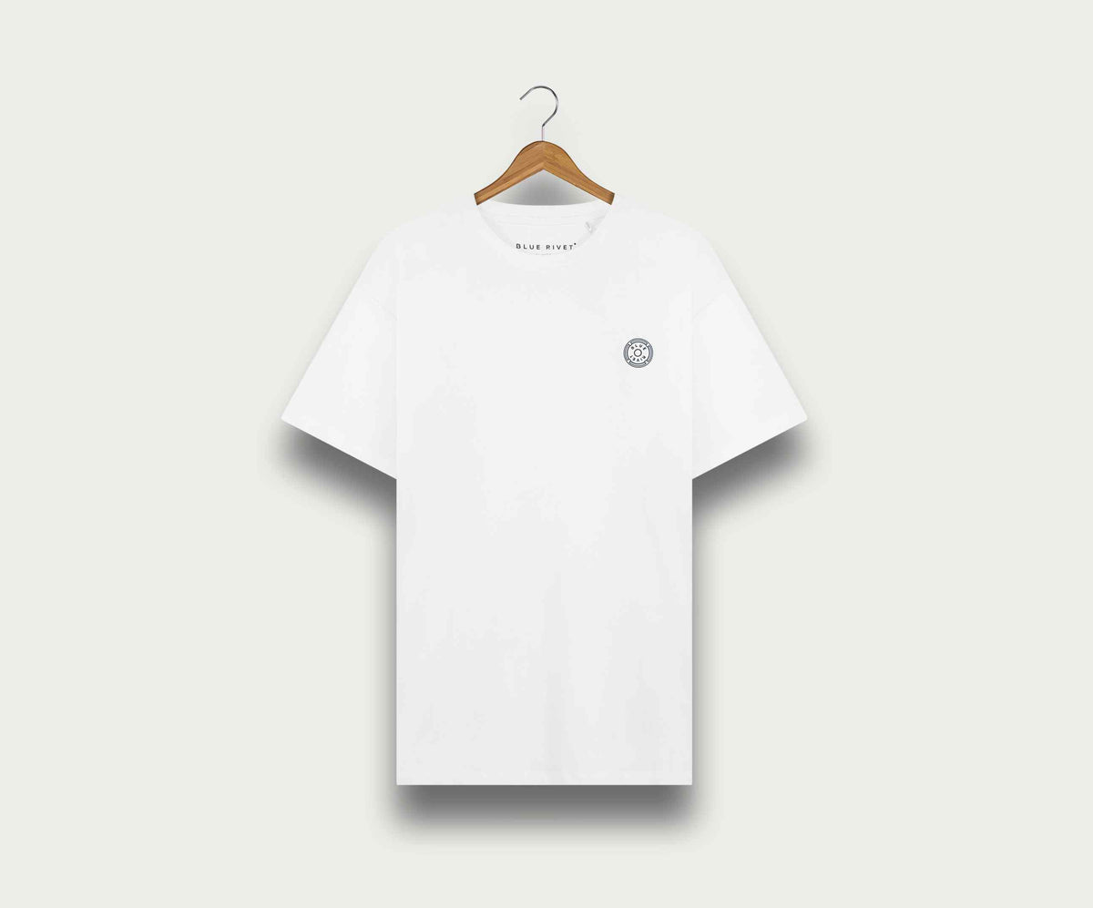 Een regular fit, effen wit N01 T-shirt van Blue Rivet Jeans met een klein, rond logo op de linkerborst, elegant tentoongesteld op een houten hanger tegen een lichtgrijze achtergrond.