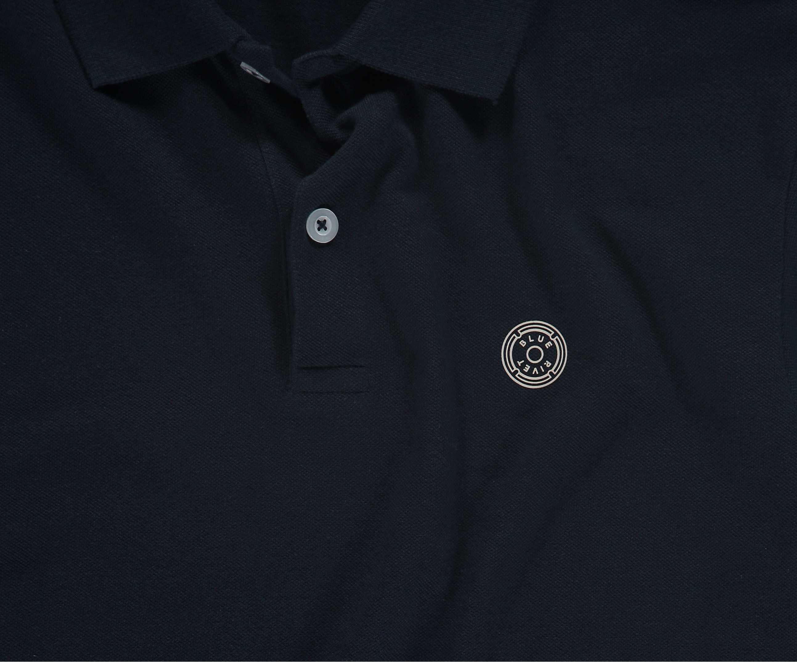 De marineblauwe N01 Polo van Blue Rivet Jeans heeft een kraag met knopen en een gestileerd zilveren cirkelvormig embleem op de linkerborst. De polo heeft korte mouwen.