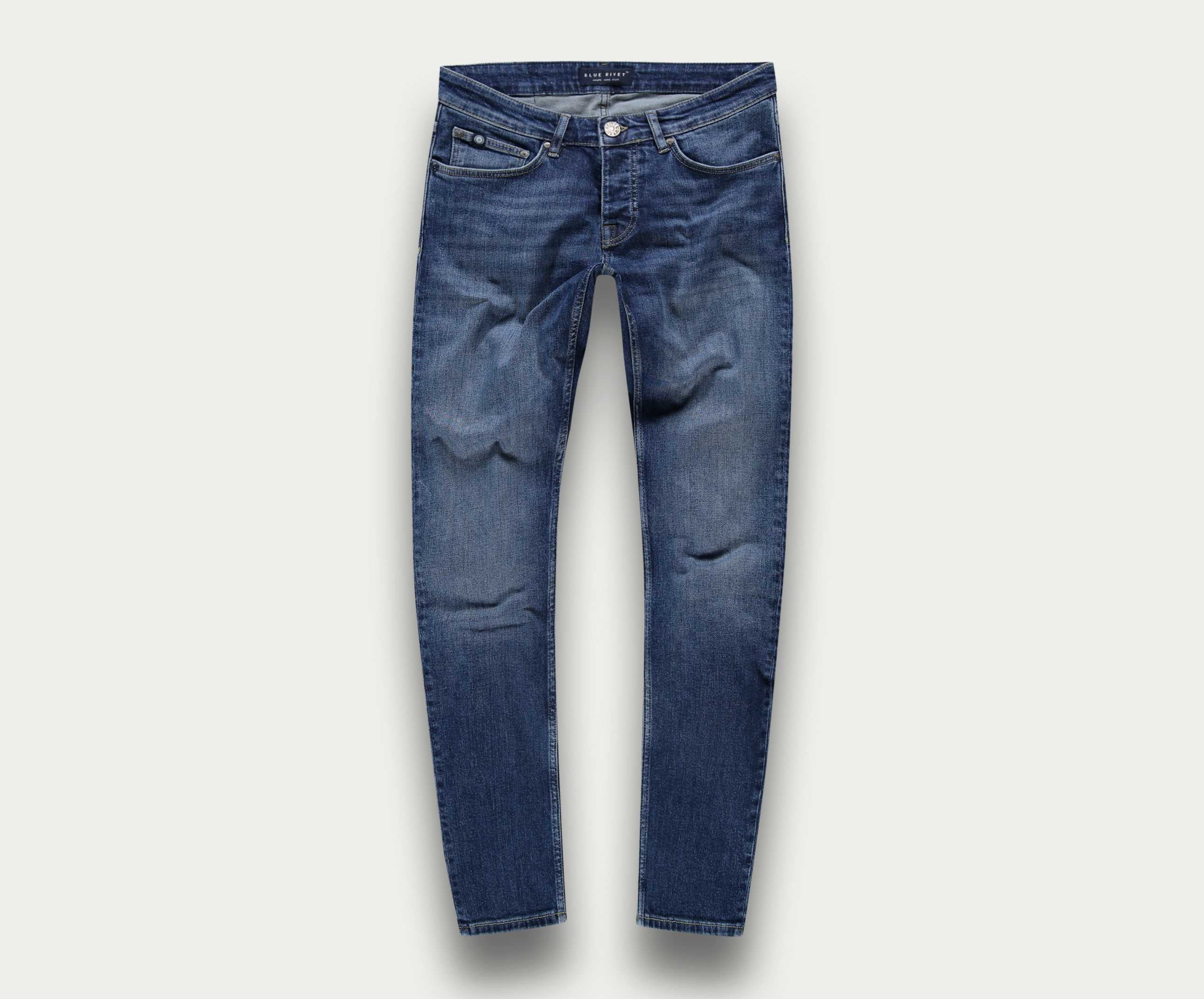 De N01 Slim Indigo Used jeans van Blue Rivet Jeans worden plat tegen een lichte achtergrond getoond, waarbij het klassieke five-pocket design en subtiele dijvervaging worden getoond. Gemaakt van premium stretchstof, bieden ze ongeëvenaard comfort en stijl.