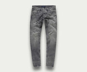 De N01 Slim Light Grey Used van Blue Rivet Jeans worden getoond tegen een eenvoudige, lichte achtergrond. Deze stretchjeans hebben een klassiek five-pocket-ontwerp met een slim fit, compleet met subtiele kreukels op de dijen voor een natuurlijk ingedragen uiterlijk.