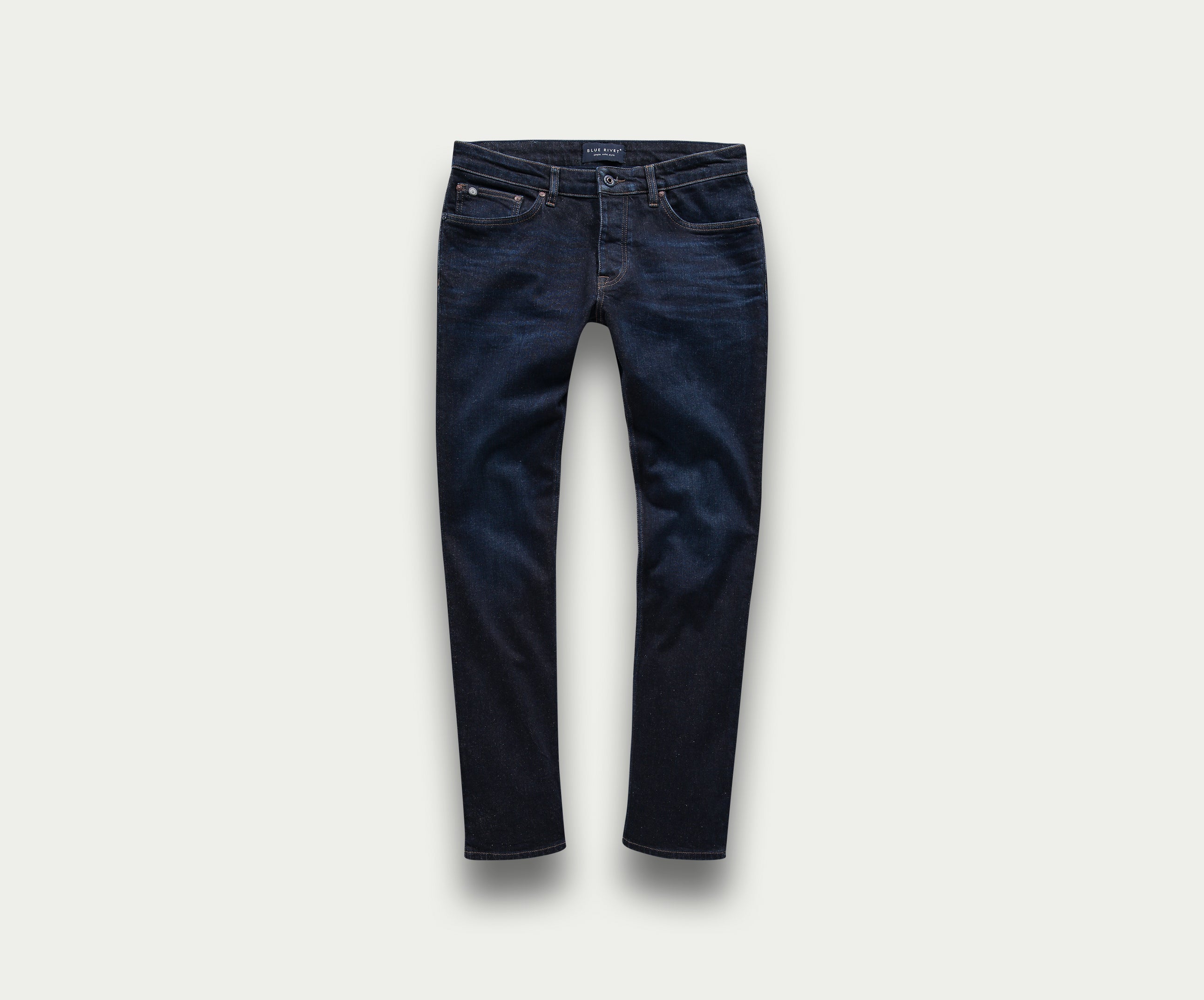 Een premium paar The N01 Slim Dark Indigo jeans van Blue Rivet Jeans, met een slim fit die plat ligt tegen een lichte achtergrond. Deze stijlvolle jeans hebben een klassiek five-pocket design, zichtbare stiksels en een vleugje stretch voor extra comfort.