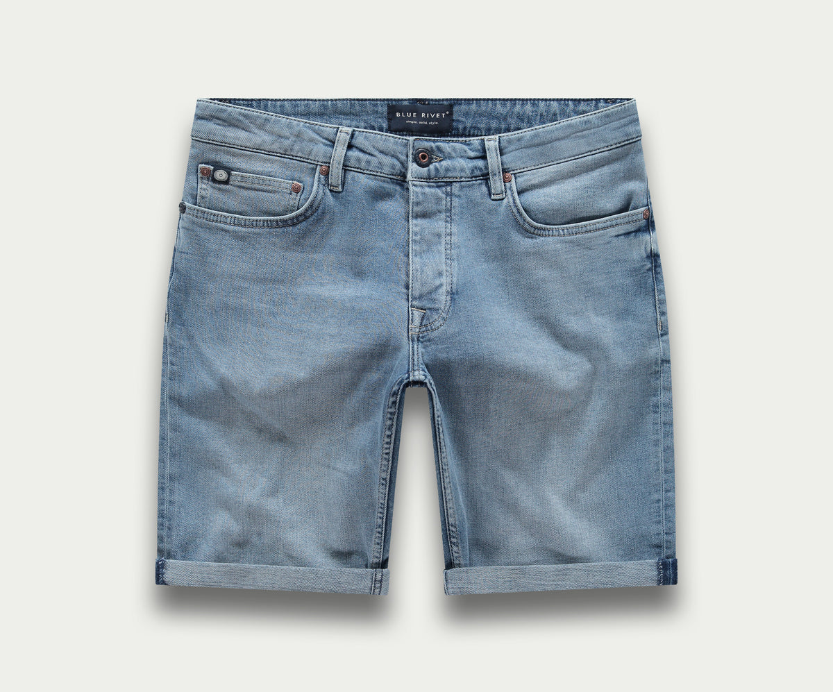 De N01 Short Stone Bleached van Blue Rivet Jeans is een lichtblauwe denim short met gerolde zomen, zakken aan de voorkant en een tailleband met riemlussen. De "korte broek" wordt getoond tegen een subtiele lichte achtergrond.