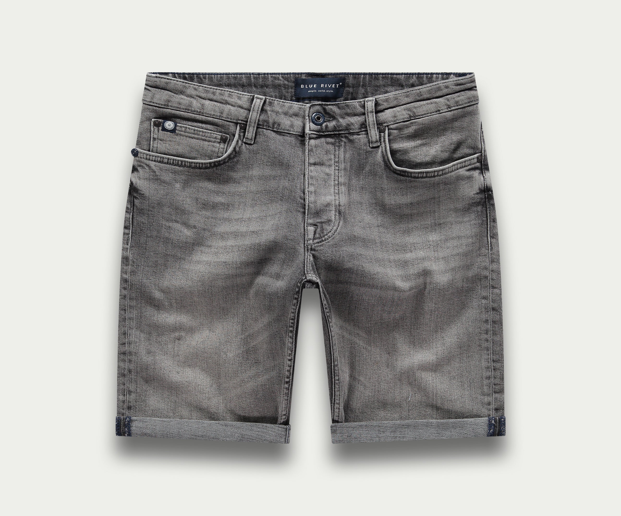 De N01 Short Light Grey Used van Blue Rivet Jeans is een paar grijze denim shorts met een subtiel vervaagde look. Ze zijn uitgerust met riemlussen, een knoop- en ritssluiting en hebben twee voorzakken en twee achterzakken. Het ontwerp is afgewerkt met omgeslagen zomen.